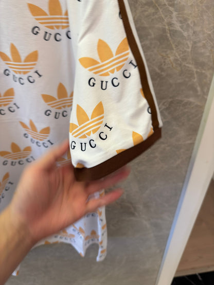 Polo con estampado de trébol de Gucci x Adidas en blanco y marrón con logotipos icónicos