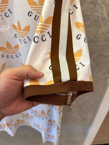 Polo con estampado de trébol de Gucci x Adidas en blanco y marrón con logotipos icónicos