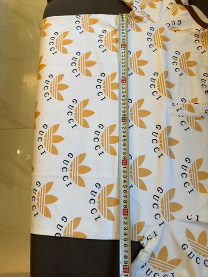 Polo con estampado de trébol de Gucci x Adidas en blanco y marrón con logotipos icónicos
