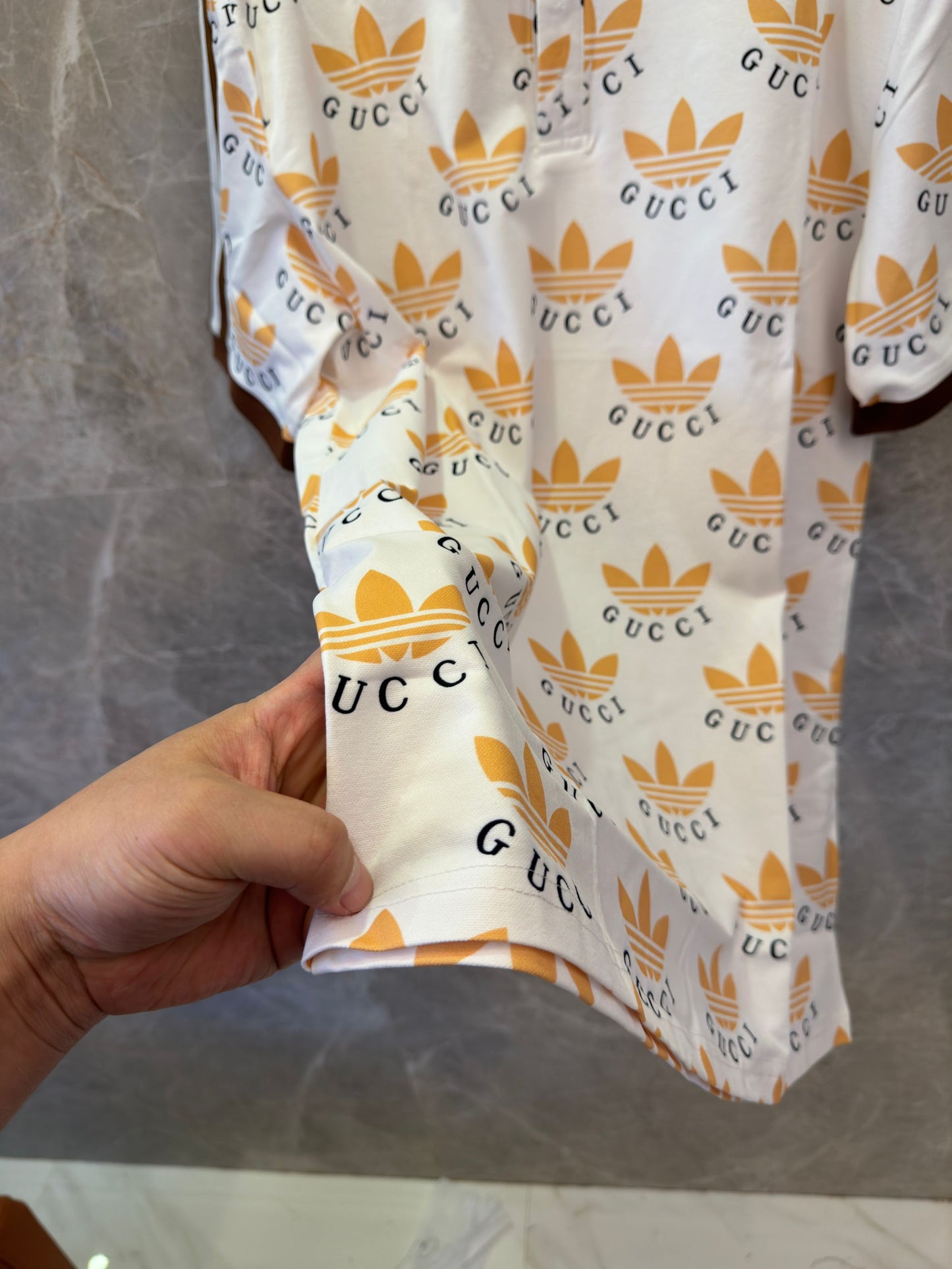 Polo con estampado de trébol de Gucci x Adidas en blanco y marrón con logotipos icónicos