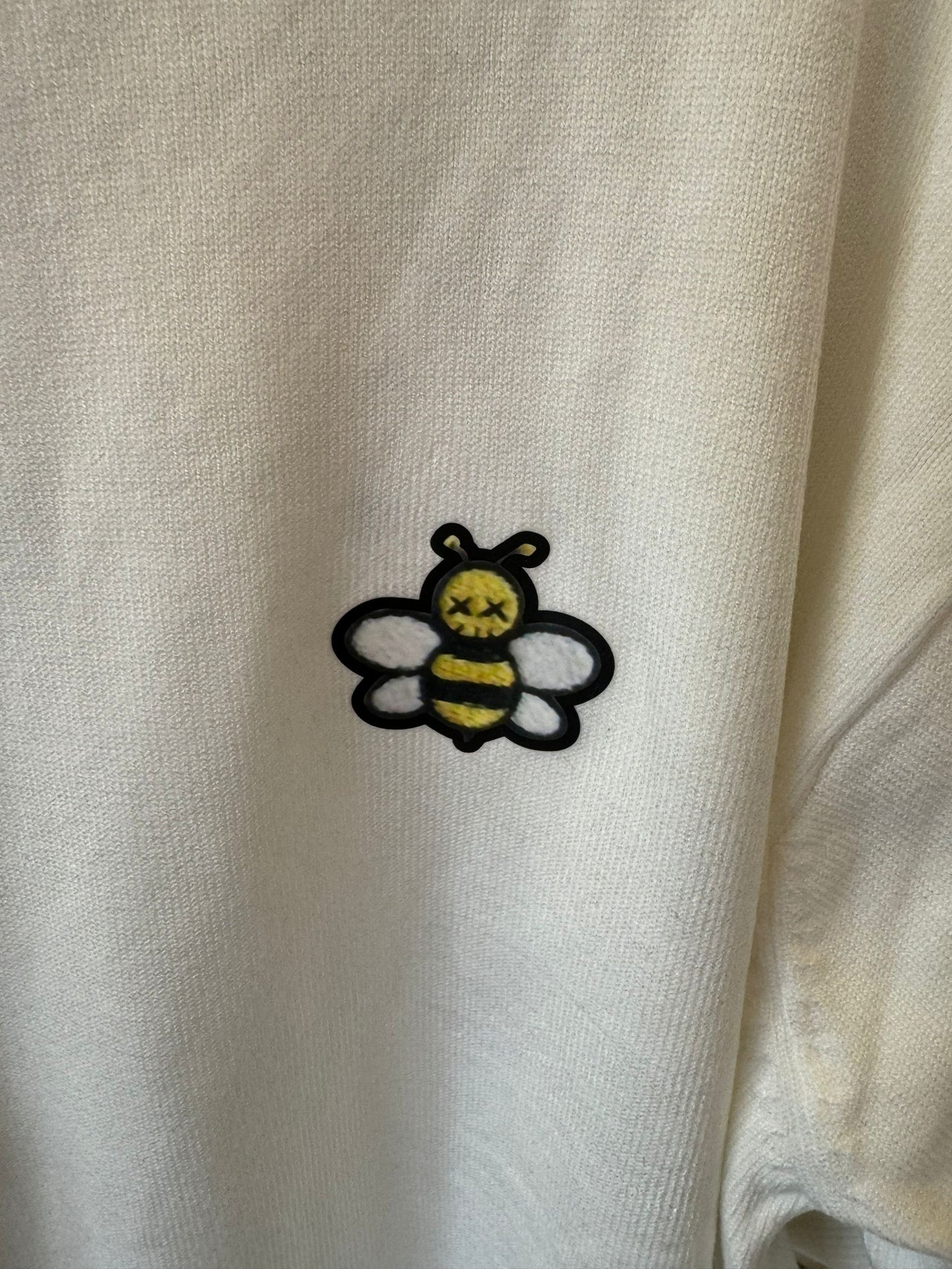 Suéter color marfil con abeja bordada de Christian Dior y detalle de rayas