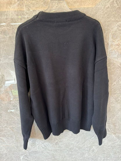 Suéter de punto negro con bordado de corazón de Ami: un jersey acogedor con el característico logotipo "A" rojo.