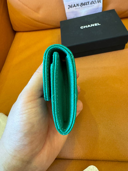Cartera clásica con solapa de Chanel: piel caviar verde esmeralda con logo CC dorado.