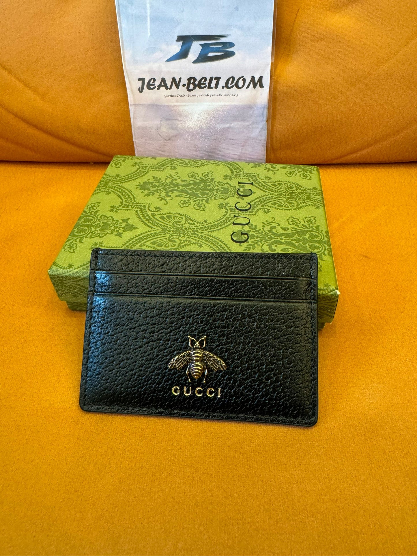 Tarjetero Gucci de piel negra con logotipo de abeja dorado