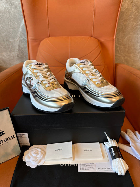Chanel CC Trainers: zapatillas blancas y doradas con el icónico logotipo.
