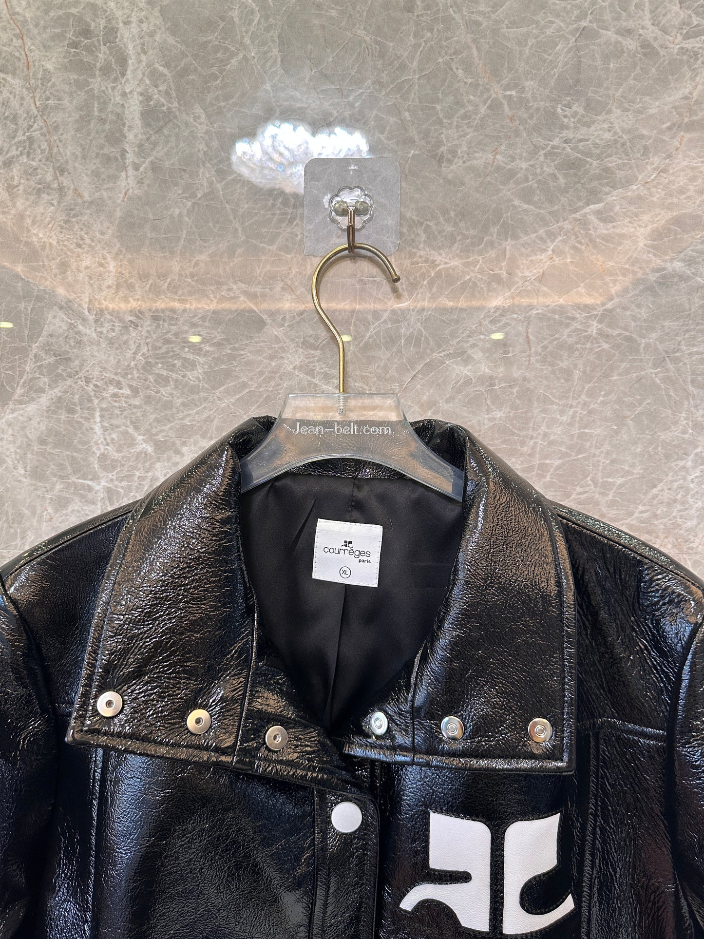 Chaqueta de charol negro de Courrèges: la emblemática chaqueta de moto brillante
