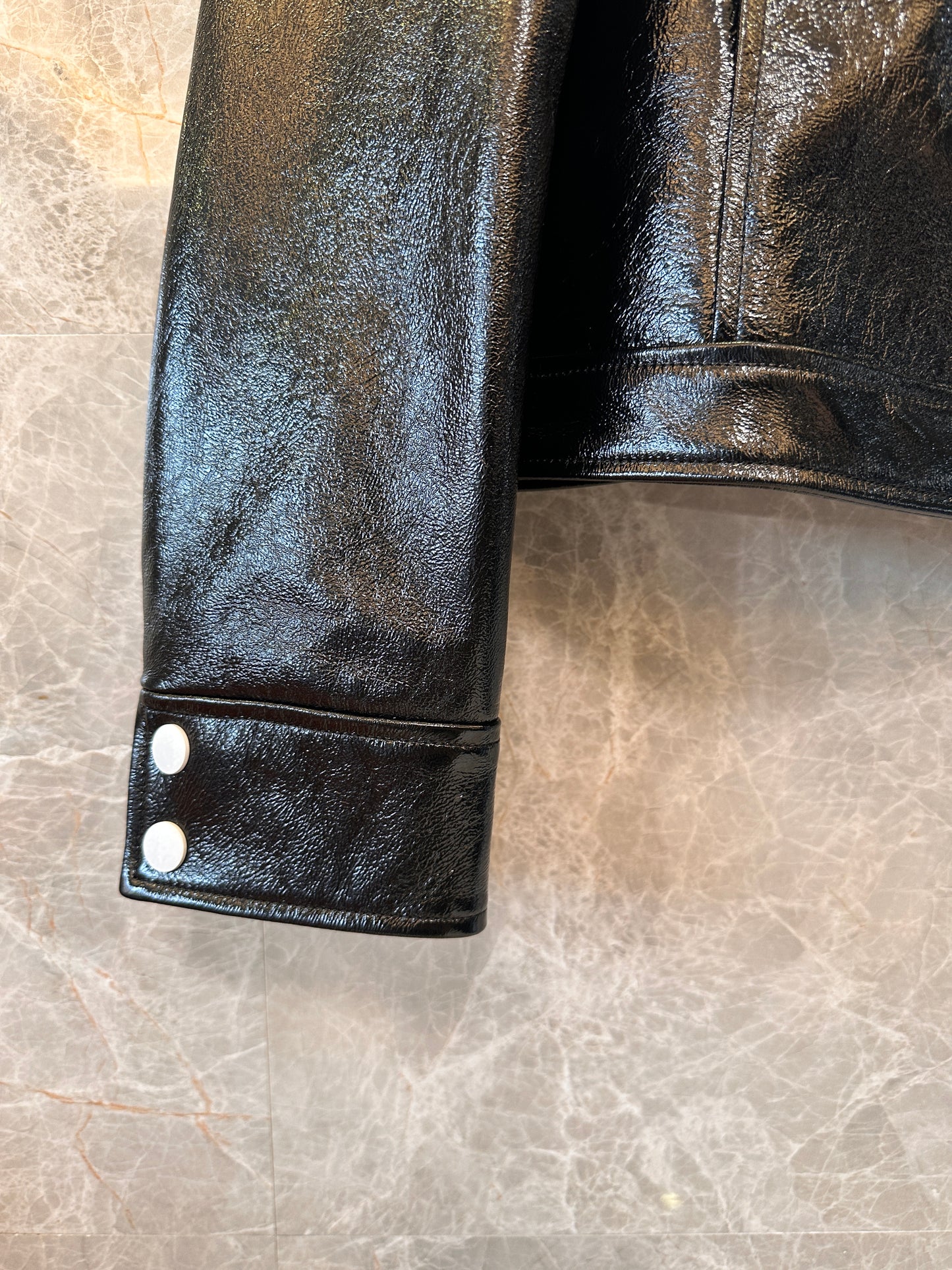 Chaqueta de charol negro de Courrèges: la emblemática chaqueta de moto brillante