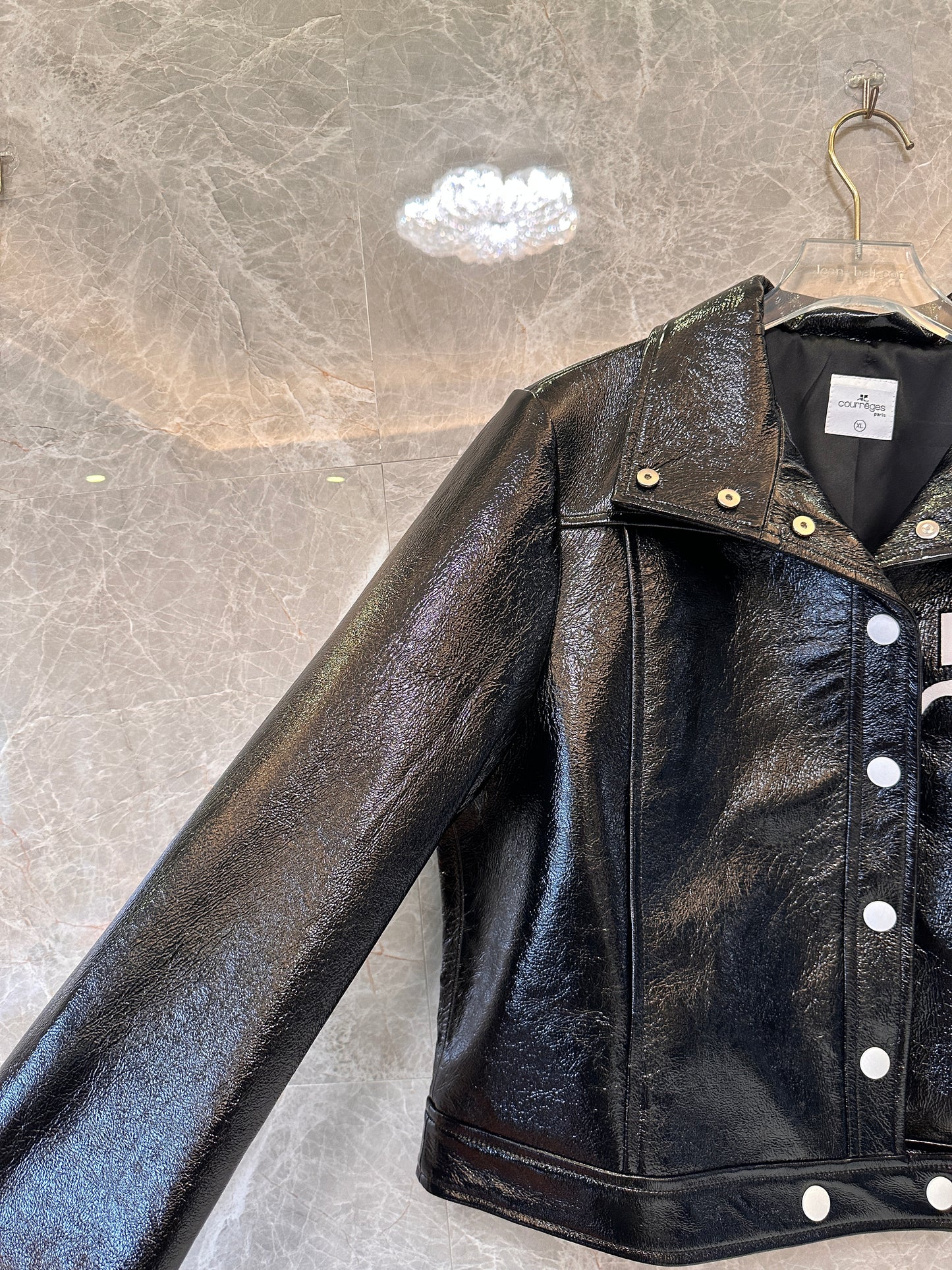 Chaqueta de charol negro de Courrèges: la emblemática chaqueta de moto brillante